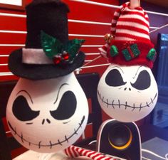 two decorated pumpkins sitting on top of a table next to each other with holiday decorations