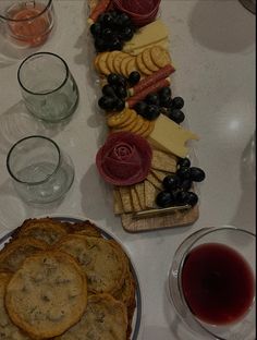 a platter of crackers, grapes and cheese on a table