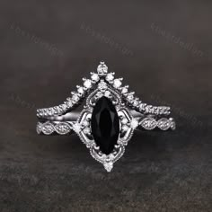 a black and white diamond engagement ring with an intricate design on the side, set in 18k white gold