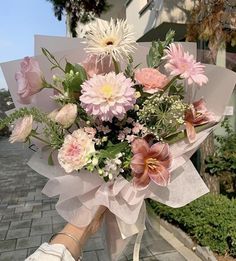 a woman holding a bouquet of flowers on the street