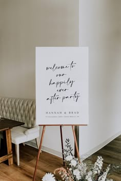 a welcome sign sitting on top of a wooden easel in front of a couch