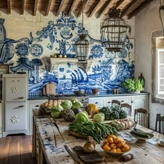 a kitchen with blue and white tiles on the wall, wooden table surrounded by fruits and vegetables