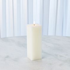 a white candle sitting on top of a table