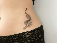 a woman's stomach with a tiger tattoo on the side of her belly,