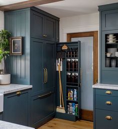 a kitchen with blue cabinets and white counter tops, an open pantry in the center