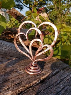 a metal heart sculpture sitting on top of a wooden table