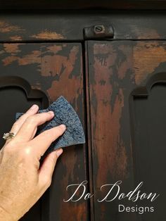 a person is cleaning an old dresser with a cloth