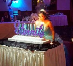 a woman sitting in front of a cake with candles on it that says'birthday '