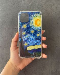 someone is holding up their phone case with the starry night painting on it's back