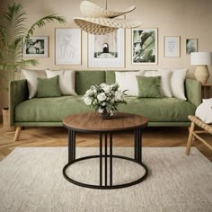 a living room with green couches and pictures on the wall above it, along with a coffee table