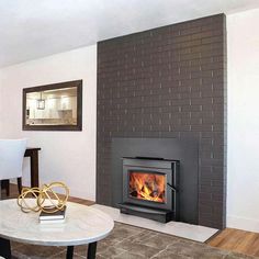 a living room with a fire place next to a table and chairs in front of a fireplace