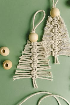 a small christmas tree made out of rope and wood beads on a green surface with other items