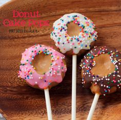 three donuts with sprinkles are on a stick