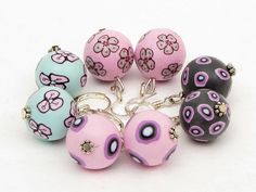 six pink and blue beads with flowers on them are sitting next to each other in a circle