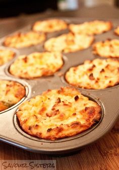 there are many small pizzas in the muffin tin