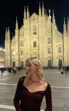 a woman standing in front of a large building