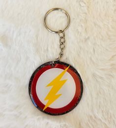 a key chain with a flash logo on it sitting on a white fur surface,