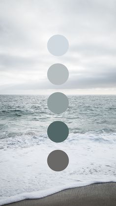 a person standing in front of the ocean with five circles above their head and four on each side