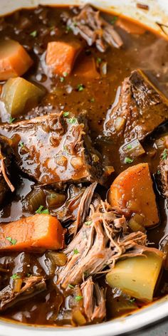 a white bowl filled with beef stew and carrots