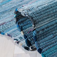 a pile of blue rugs sitting on top of a wooden floor