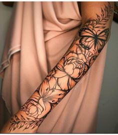 a woman's arm with flowers and butterflies on it