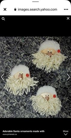 three white wooly santa claus ornaments hanging on a black and silver wallpaper background