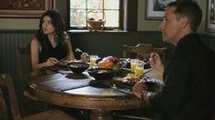 a man and woman sitting at a table with plates of food in front of them