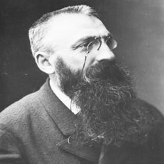 an old black and white photo of a man with a long beard, wearing glasses