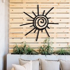 a living room with couches and plants in front of a wooden paneled wall