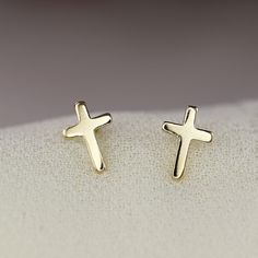 "Tiny 14k solid gold cross stud earrings.  They are perfect as second hole studs. You may buy them as single or pair. A delicate piece of religious jewelry for you or for your loved ones. DETAILS SOLD AS SINGLE OR PAIR !  14k solid gold cross stud earrings Earrings measure , length 6.5mm, width 4.5mm  Including 14k solid gold backings. * All our raw materials are sourced from US-based companies for the quality and safety of our handmade products. * These earrings are handcrafted for you in our l Gold Cross Earrings, Homesteading Animals, Redlands California, Small Earrings Gold, Cross Stud Earrings, Everyday Earrings Studs, Cross Earrings Studs, Small Workshop, Birthday List