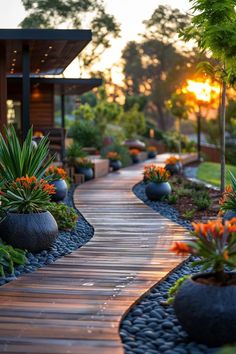 a wooden walkway surrounded by lots of plants and rocks in front of a house at sunset