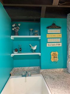 a bathroom with blue walls and white shelving above the bathtub is decorated with decorative items