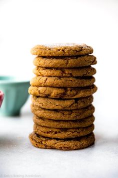 a stack of cookies sitting on top of each other next to a bowl and cup