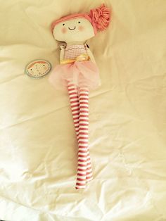 a stuffed doll laying on top of a bed