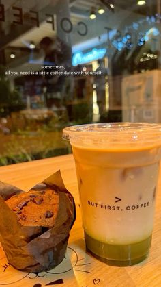 a cup of coffee next to a muffin on a table