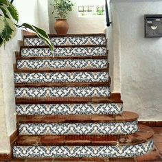 the stairs are decorated with blue and white tiles, along with potted plants on either side