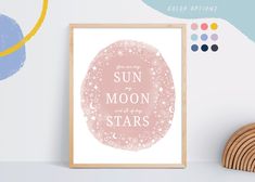 a pink poster with the words sun to moon stars on it next to a wooden shelf