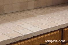 a kitchen counter with white tile on it