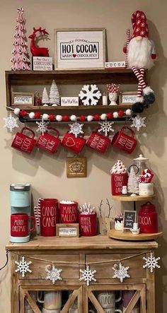 a christmas display with red and white decorations on the shelf, santa clause mugs