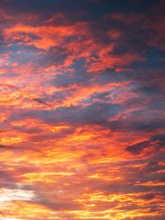 the sky is red and orange with clouds