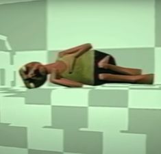 a woman laying down on top of a table next to a wall with checkered walls