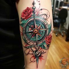 a compass and roses tattoo on the arm