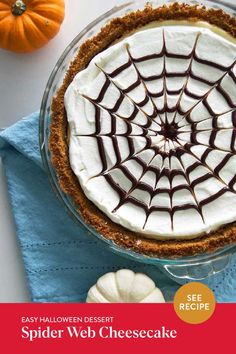 there is a pie with white frosting and chocolate decorations on the top, surrounded by mini pumpkins