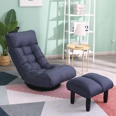 a living room with a chair and ottoman in the corner, next to a potted plant