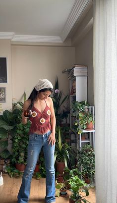 a woman standing in a room with plants