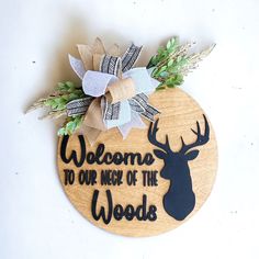 a wooden sign that says welcome to our neck of the woods with a deer's head on it