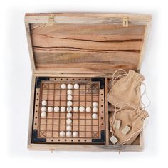 an old wooden board game with white balls in it and drawstring bag next to it