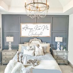 a large bed sitting under a chandelier next to a wall with writing on it