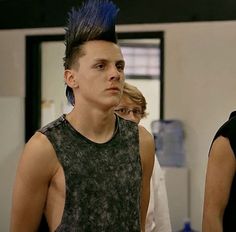 two young men with mohawks standing next to each other in front of a mirror