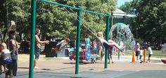 children are playing in the park with water sprinklers